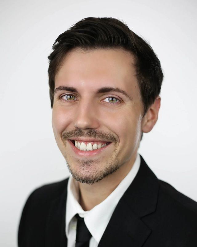 Studio headshot, suit and tie, white backdrop