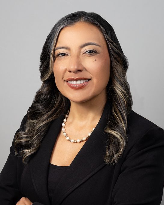 Studio headshot, black blazer, gray backdrop